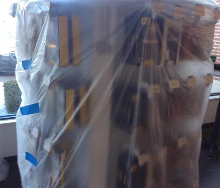 Plastic containment wrapping a counter to protect merchandise